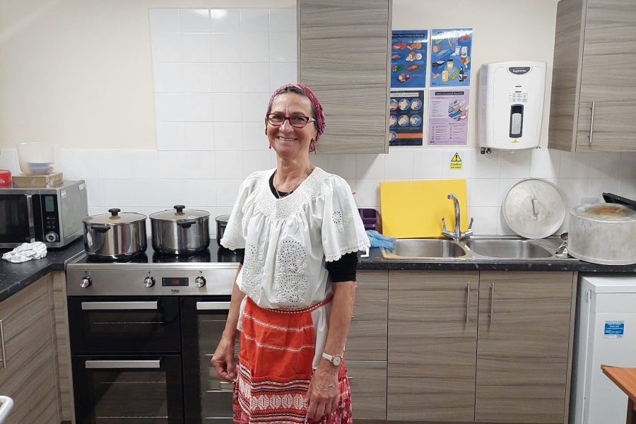 Photo of person in a kitchen wearing a colourful apron.