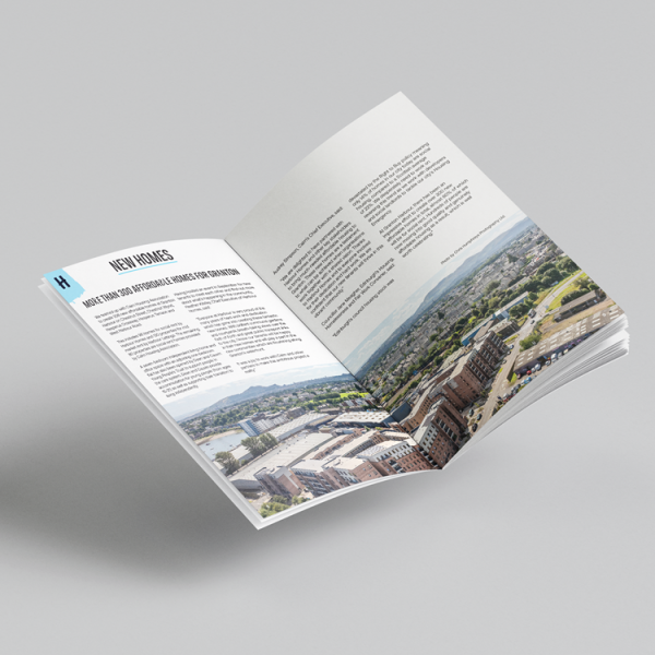 Photo of the Annual Report opened to a page titled 'New Homes'.