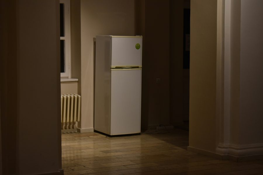 Photo of a fridge in an empty room.