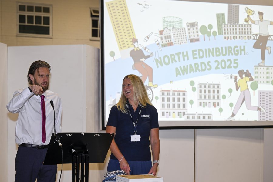 Photo of two people standing in front of a screen with text North Edinburgh Awards 2025.
