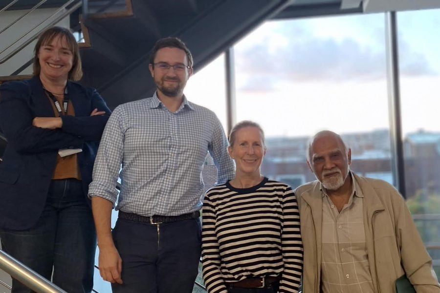 Photo of four new Board Members standing on staircase with Leith in background.