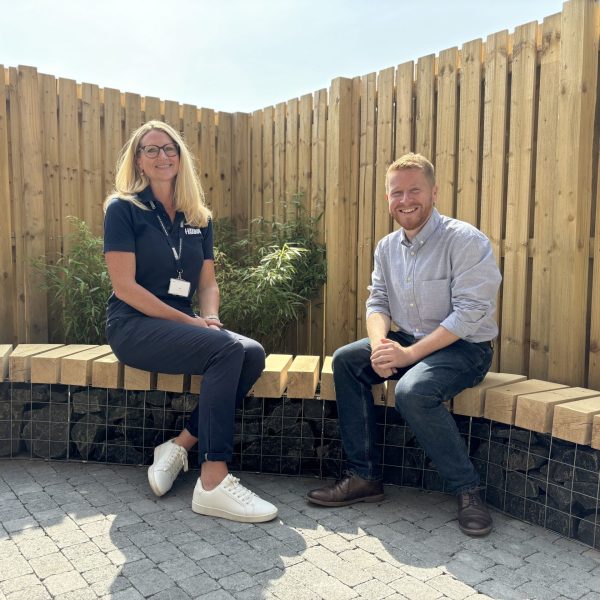 Photo of Heather and Gary sitting on a stone and wood bench in the house garden.