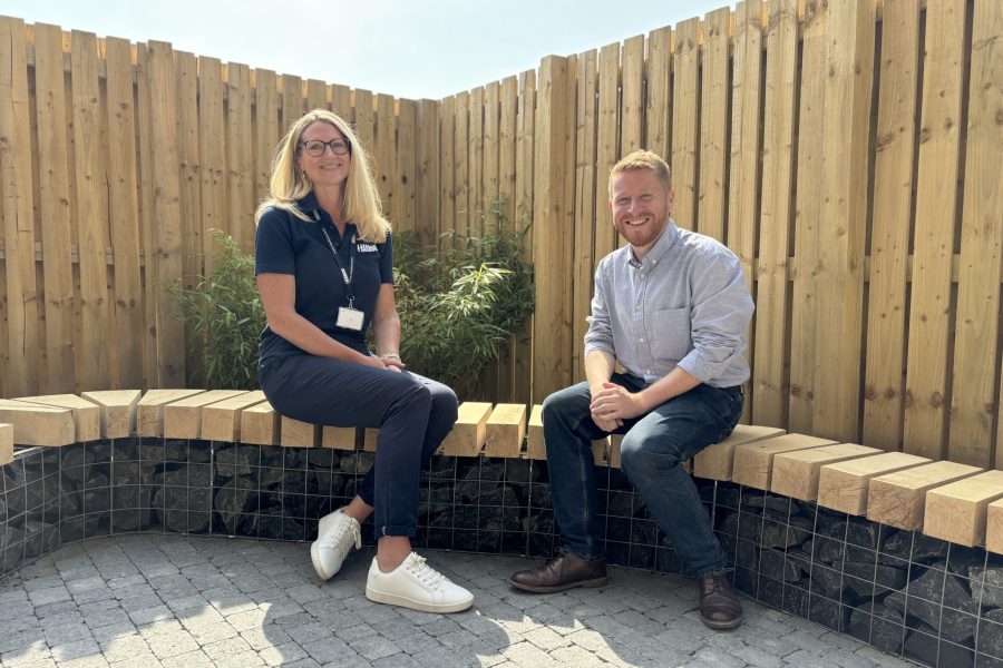 Photo of Heather and Gary sitting on a stone and wood bench in the house garden.